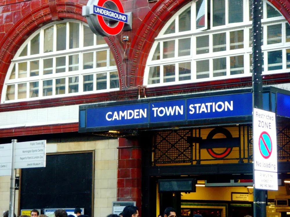 Wejście na stację Camden Town ze znakiem London Underground powyżej i ludźmi przechodzącymi poniżej.
